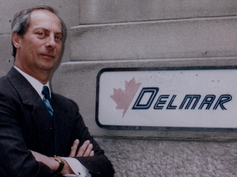 Robert Cutler, founder of Delmar standing in front of an early version of the Delmar sign.